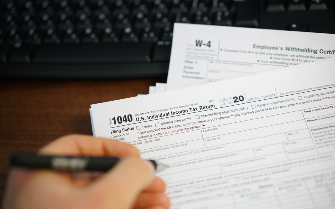 A close-up of a person completing a 1040 tax form